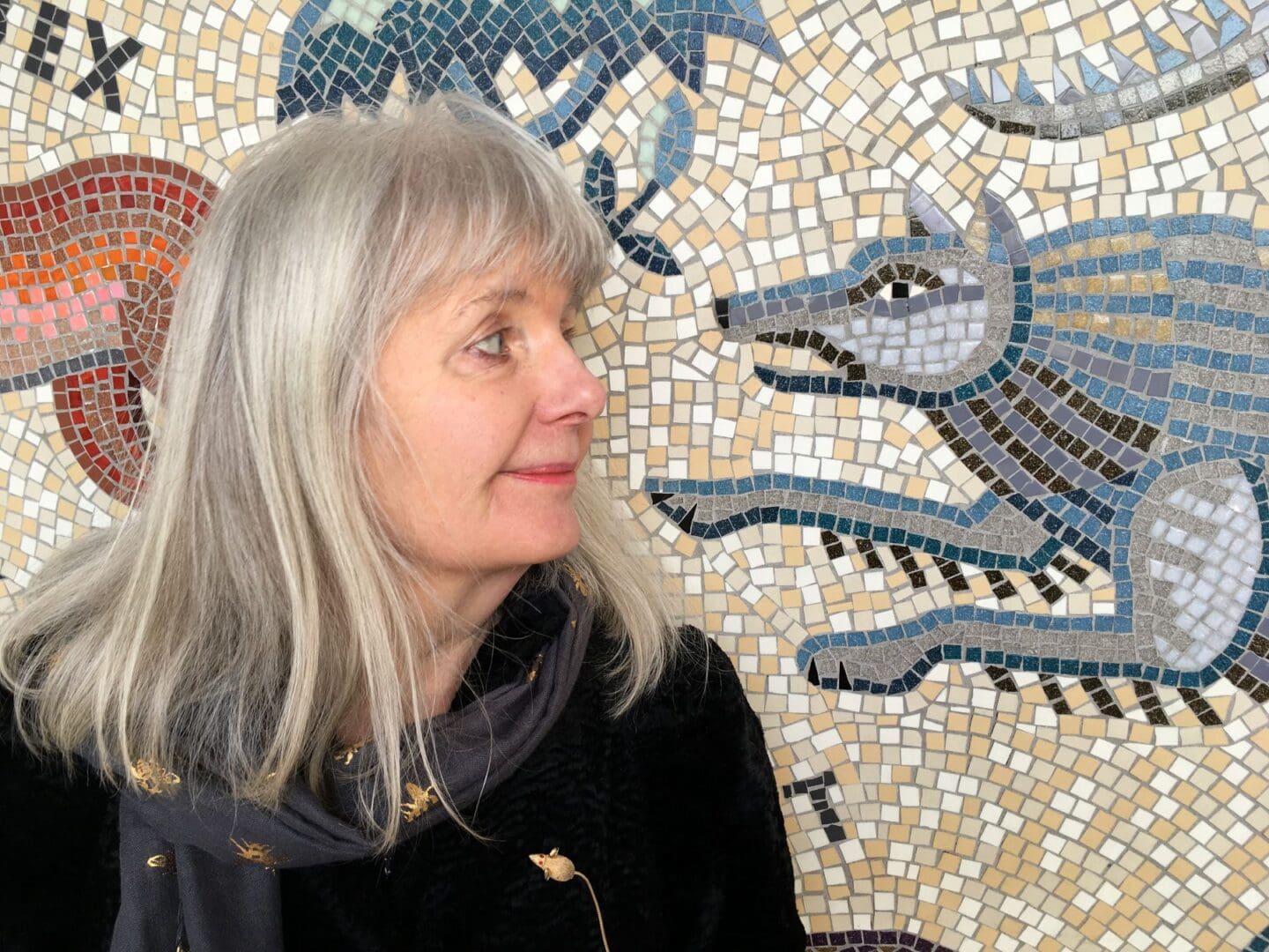 Tessa Featured Image Tessa hunking stood before a mosaic artwork of a wolf