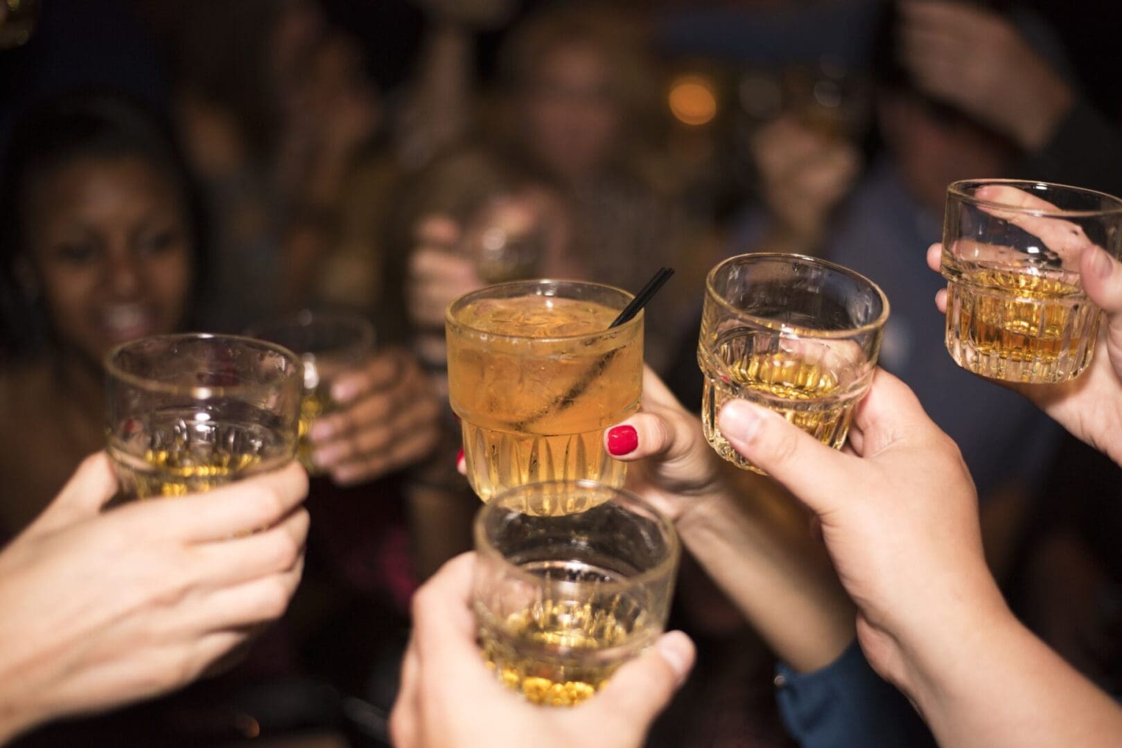 People clinking drinks together.