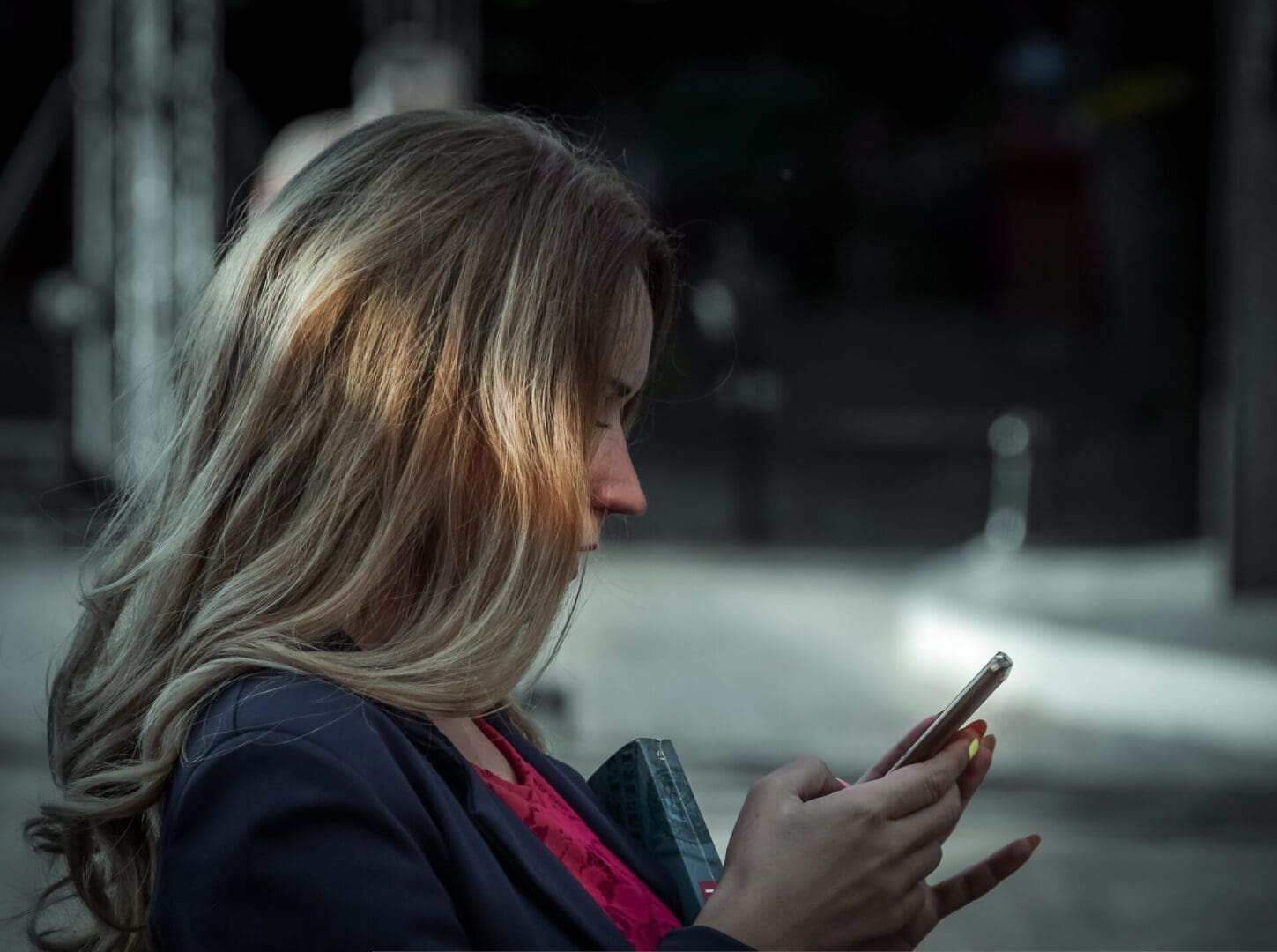 Woman looking at her phone while sat on a bench