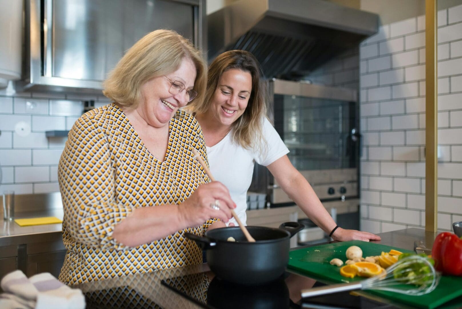 pexels-kampus-8507650 Two women smiling while cooking