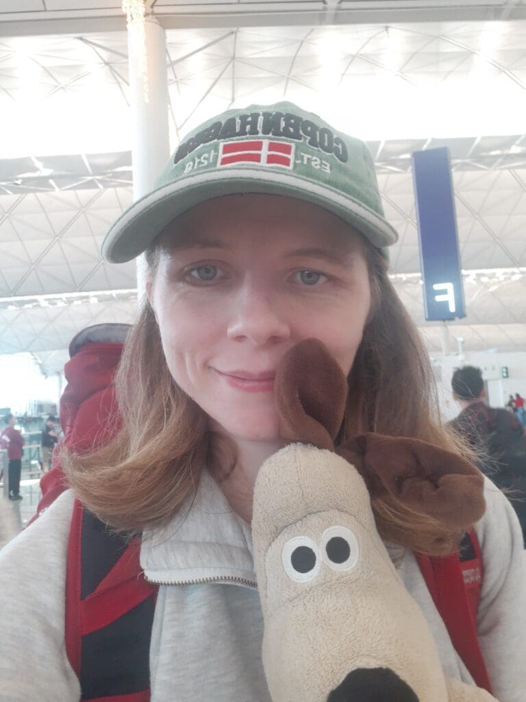 Kate holds a dog stuffed toy in the Hong Kong International Airport