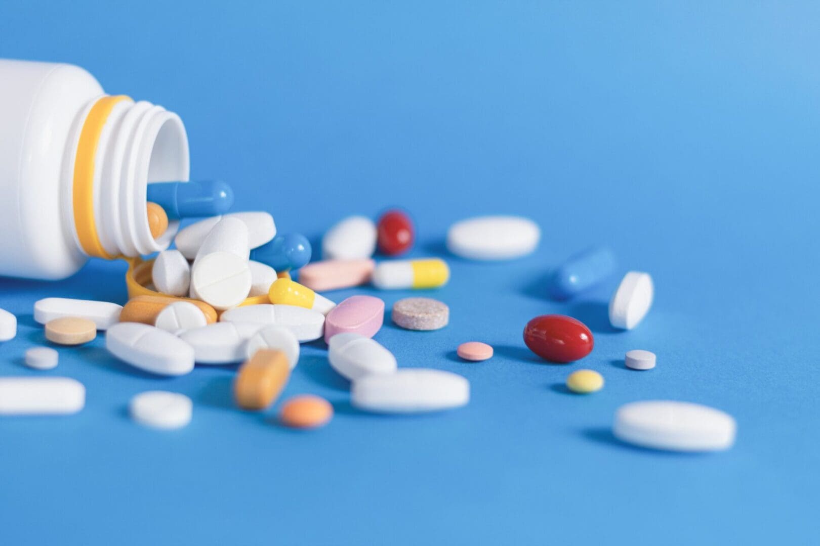 kravaivan11-medicine-8287535 A photo of a spilled pill bottle in front of a blue background